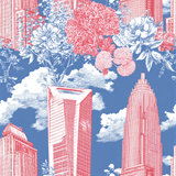 Uptown Jubilee Wallpaper with red buildings and white floral patterns over a blue, cloud-filled background.

