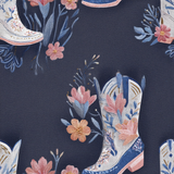 Floral cowboy boot wallpaper from Bluebonnet, featuring a repeating pattern on a textured, dark blue background.